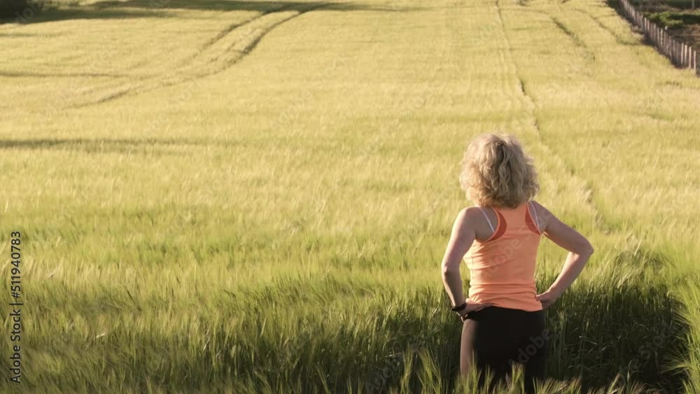young caucasian woman inside a barley field in spring with wind. 4K. Ayegui, Navarre, Spain, Europe. young caucasian woman inside a barley field in spring with wind. 4K. Ayegui, Navarre, Spain, Europe.
