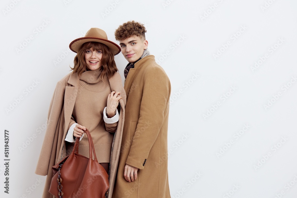 a happy couple a man and a woman stand in stylish autumn clothes on a white background close to each other and smile happily a happy couple a man and a woman stand in stylish autumn clothes on a white background close to each other and smile happily