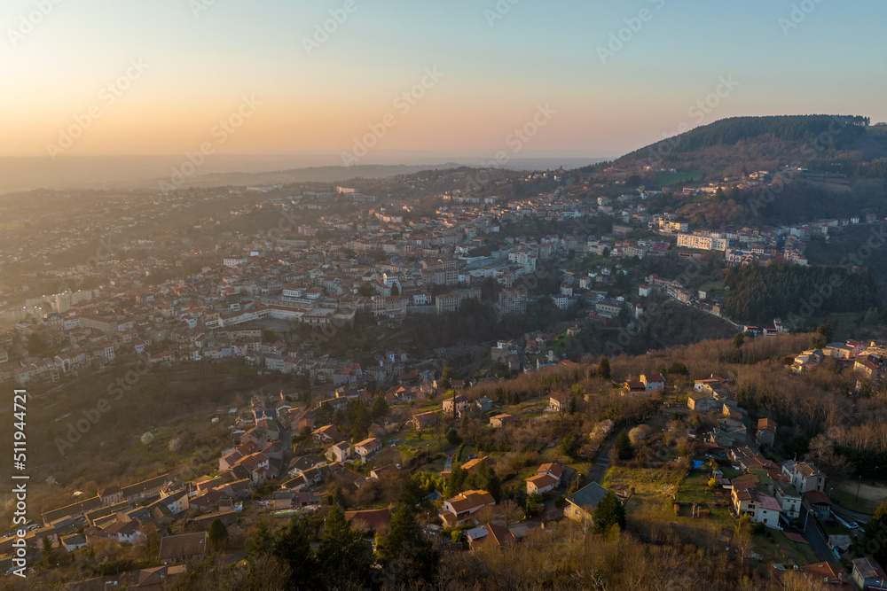 Aerial view of dense historic center of Thiers town in Puy-de-Dome department, Auvergne-Rhone-Alpes region in France. Rooftops of old buildings and narrow streets at sunset