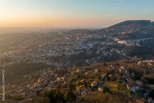 Aerial view of dense historic center of Thiers town in Puy-de-Dome department, Auvergne-Rhone-Alpes region in France. Rooftops of old buildings and narrow streets at sunset