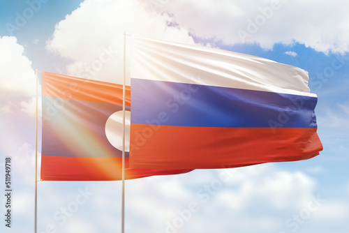 Sunny blue sky and flags of russia and laos