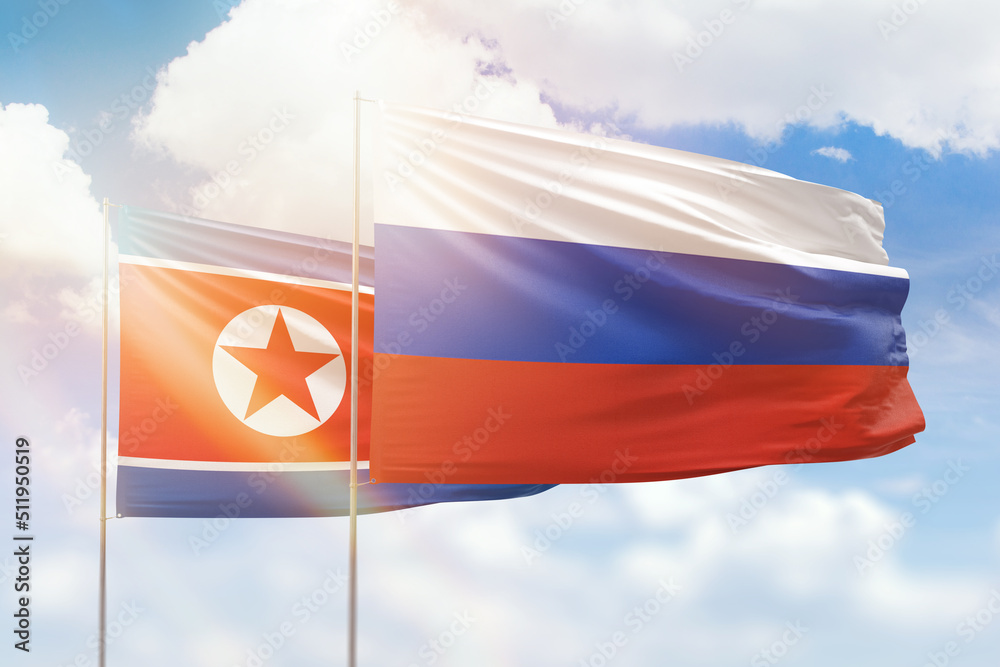 Sunny blue sky and flags of russia and north korea Sunny blue sky and flags of russia and north korea