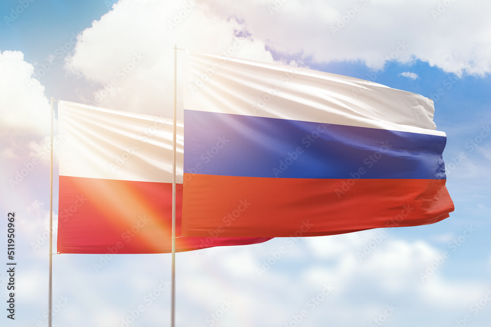 Sunny blue sky and flags of russia and poland Sunny blue sky and flags of russia and poland