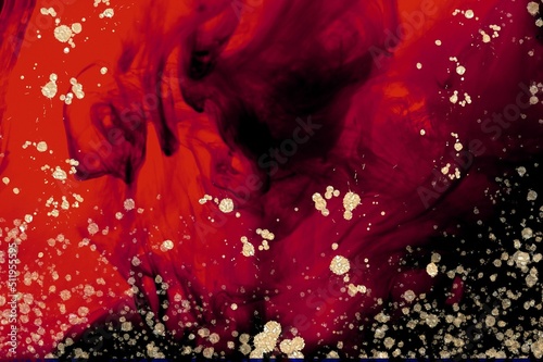 Golden drops and spatter on red and black Alcohol ink fluid abstract texture fluid art with gold glitter and liquid