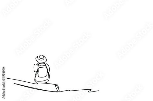 A young woman is sitting on a piece of wood. adventurer nature lover tourist in big holiday hat sits back