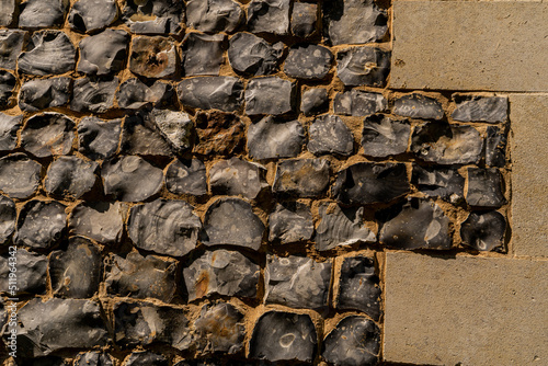 Closeup on various flint stones used in UK as a building material in architecture. Flint is the hardest of building stones, used by the Romans for castle walls and by medieval masons for churches photo