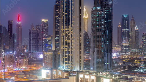 Row of the tall buildings around Sheikh Zayed Road and DIFC district aerial day to night timelapse in Dubai