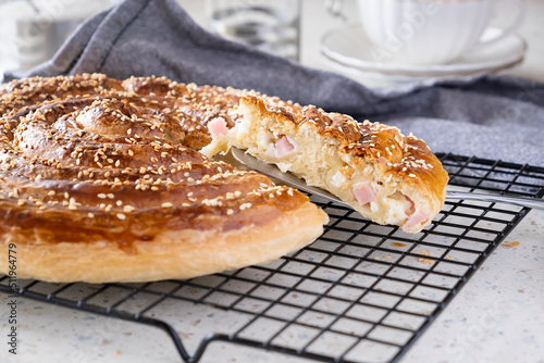 Homemade burek rolled pie with cheese, ham and sesame. Selective focus. photo