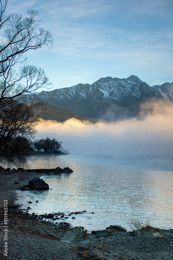 Misty winter morning over Frankton Arm, Queenstown, New Zealand. The Remarkables mountain range in the background. 