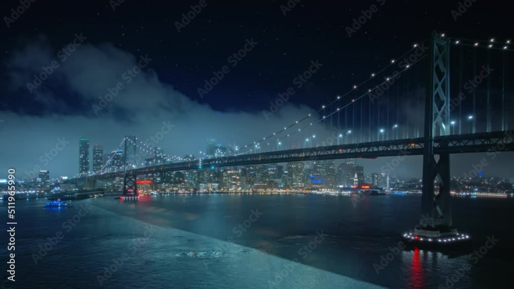 Beautiful Aerial Drone Hyperlapse view of urban San Francisco Bay bridge and financial downtown with tall skyscrapers. Flashing City lights at night, Hyper Lapse of clouds movement above San Francisco Beautiful Aerial Drone Hyperlapse view of urban San Francisco Bay bridge and financial downtown with tall skyscrapers. Flashing City lights at night, Hyper Lapse of clouds movement above San Francisco
