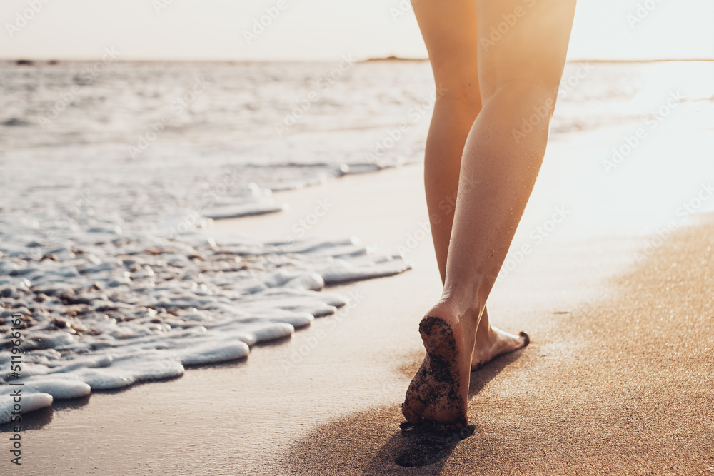 Beach travel - woman walking on sand beach leaving footprints in the ...