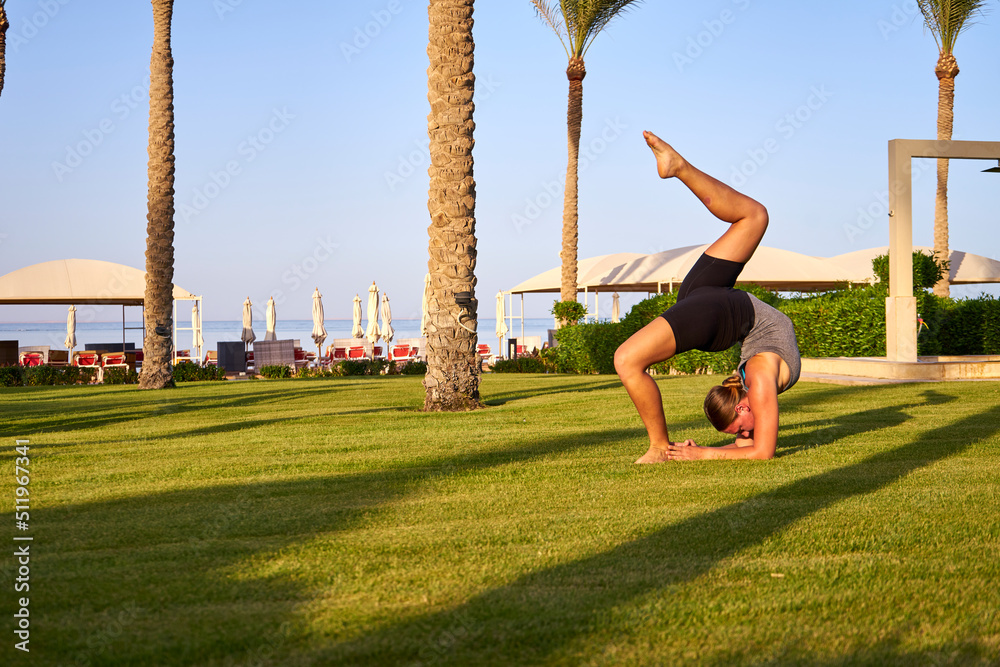 Young Girl Practicing Yoga On Beach At Sunset, Beautiful Woman Summer Vacation Meditation Seaside Sea Ocean Holiday TravelCaucasian woman with yoga posture on the beach at sunset. 