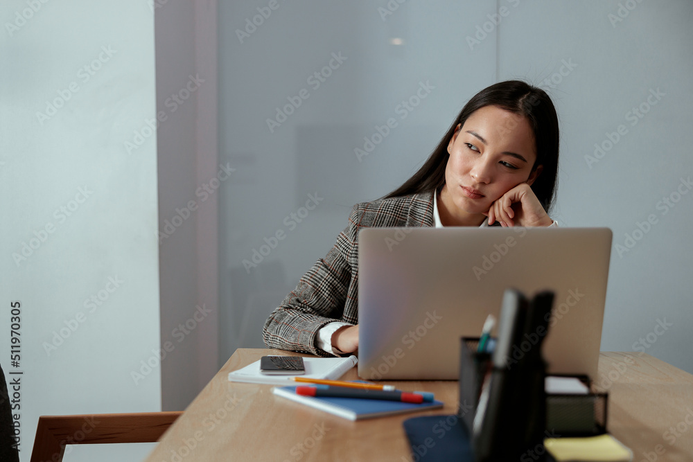 Portrait of tired beautiful business asian woman working in office use computer and looking away Portrait of tired beautiful business asian woman working in office use computer and looking away