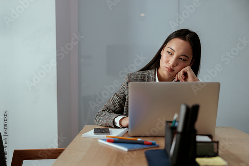 Portrait of tired beautiful business asian woman working in office use computer and looking away