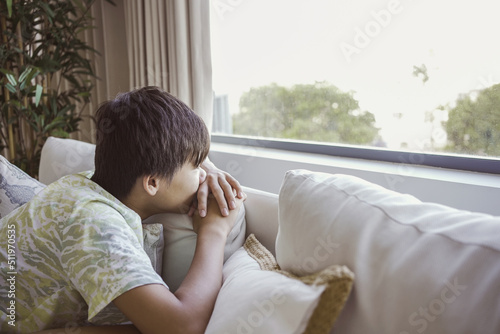 Depressed teenage boy looking out window, child mental health, stop bullying, teen autism awareness concept