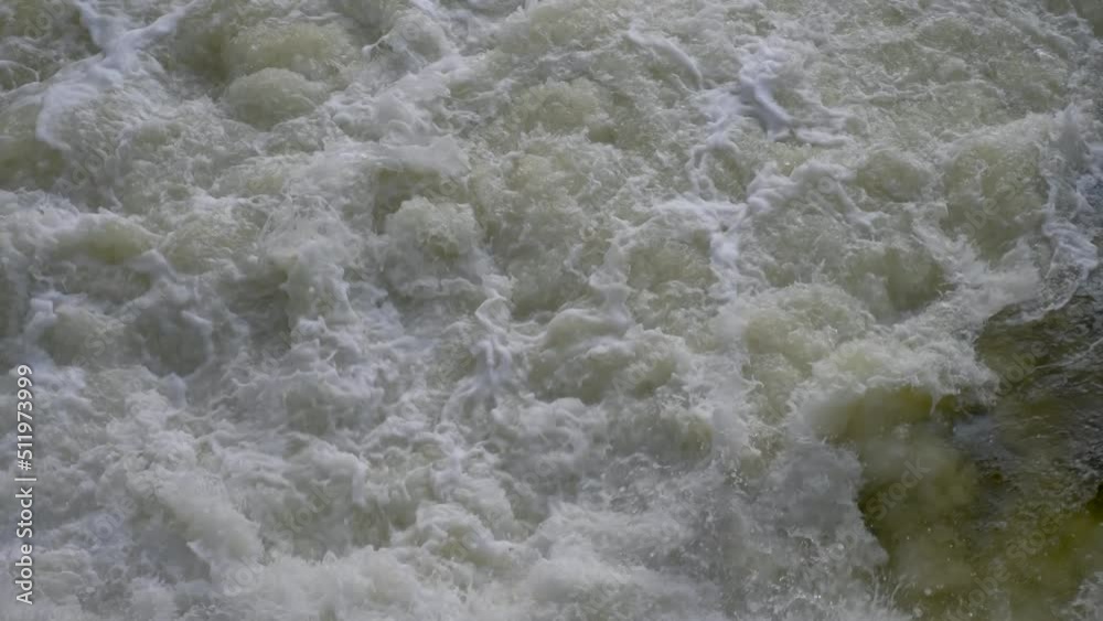 Foam water below waterfall. Bubbles to water surface. Spillway of dam near reservoir or water storage