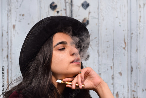 Closeup portrait of young girl smoking vaping e-cigarette