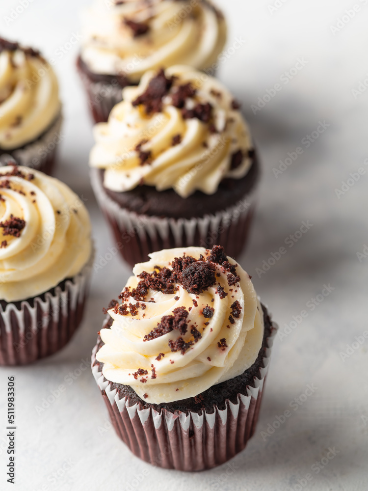 Delicious chocolate cupcakes with whipped cream topped with grated dark chocolate. Sweet food, many calories, children and youth culture, holiday, birthday, romantic date.