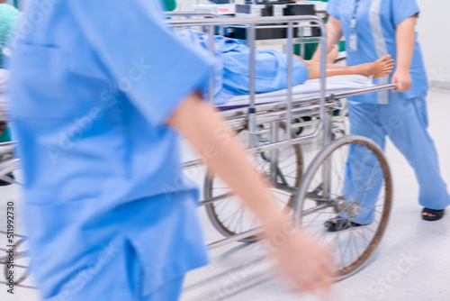 Motion blur of staff rushing patient to emergency room at hospital