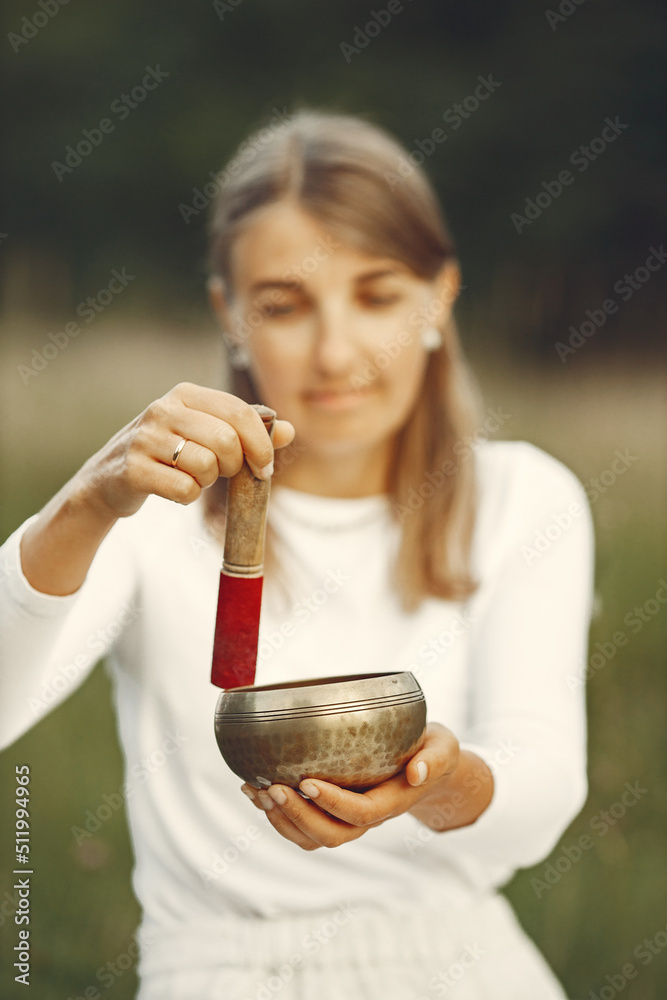 Woman holding chanting bowl in nature setting Woman holding chanting bowl in nature setting