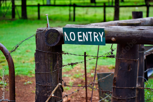 No Entry Sign on a wooden fence with old rusted gate