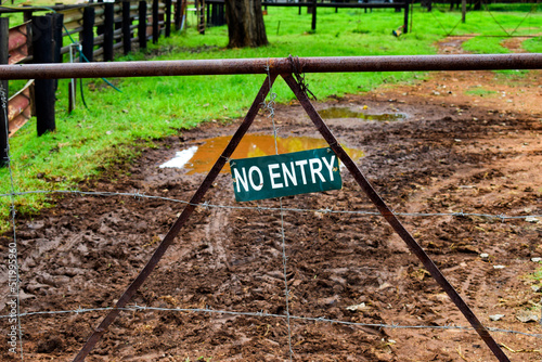 No Entry Sign on a wooden fence with old rusted gate
