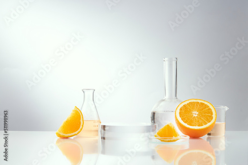 Front view of orange decorated with glassware and transparent podium in white background 