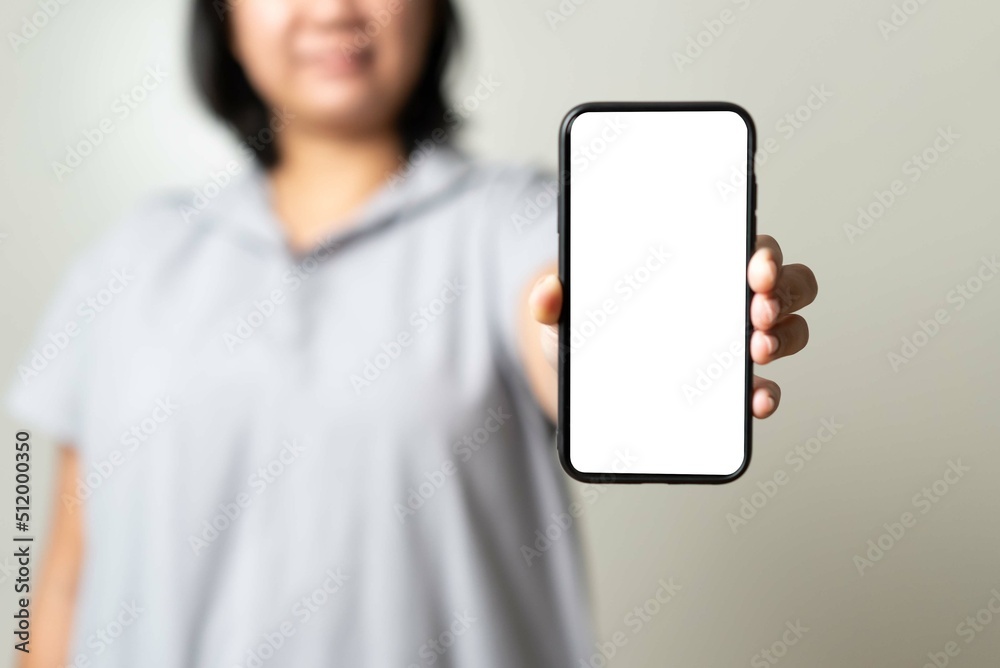Asian young woman showing empty screen mobile phone in white color free for in put text. Asian young woman showing empty screen mobile phone in white color free for in put text.