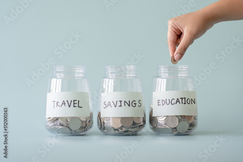 Hand putting Thai currency coin in saving jar. To save money purpose as attached and written.