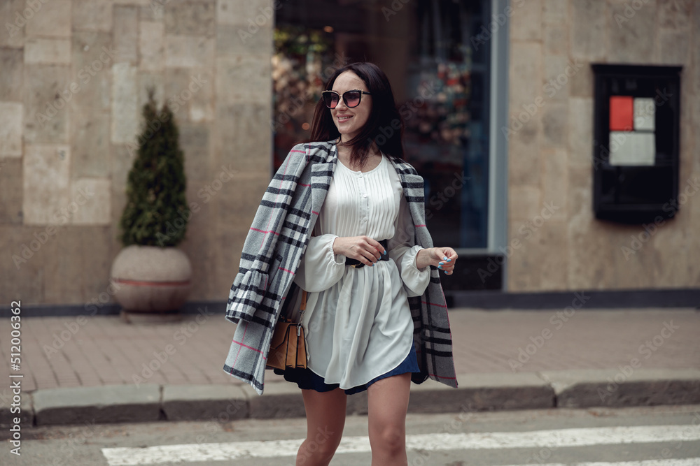 Cheerful happy beautiful woman in sunglasses and stylish clothes walking the town.