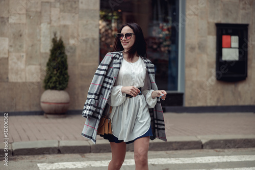 Cheerful happy beautiful woman in sunglasses and stylish clothes walking the town.