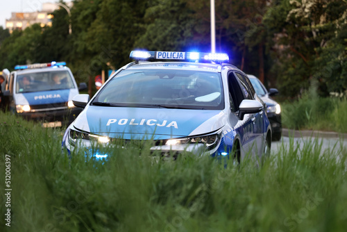 Samochód polskiej policji drogowej na sygnałach w mieście alarmowo. 