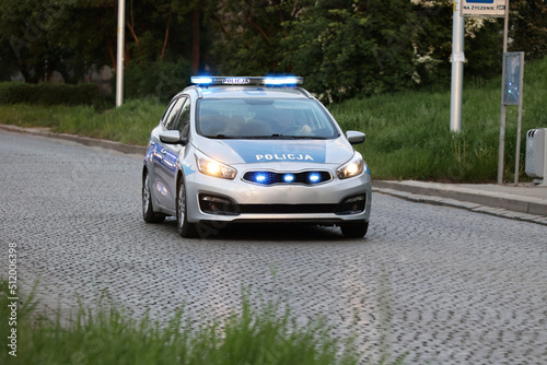 Samochód polskiej policji drogowej na sygnałach w mieście alarmowo. 