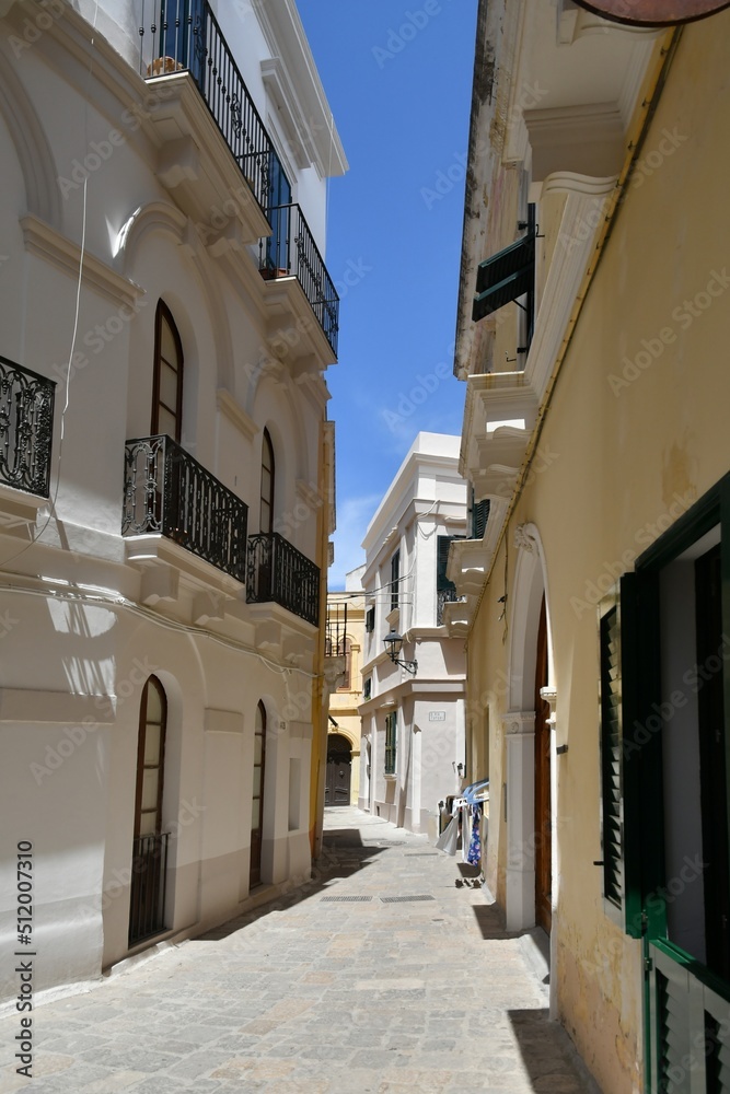 A narrow street between the old houses of Gallipoli, an old village in the province of Lecce in Italy.