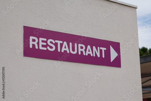 restaurant text sign on violet purple panel board facade building city street storefront © OceanProd