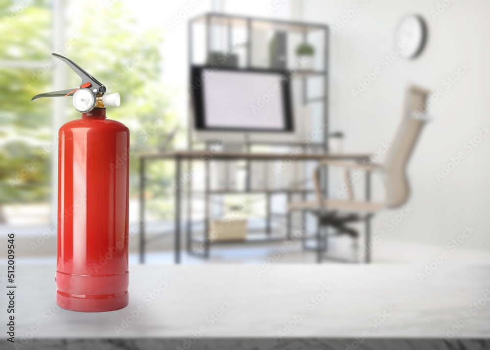 Obraz premium Fire extinguisher on stone table in office. Space for text