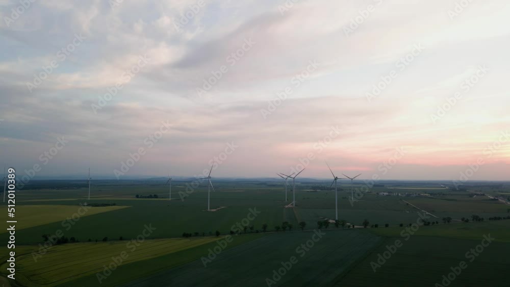 Aerial view of windmill turbine generator against beautiful sunset sky in countryside area, Concept of clean, renewable, sustainable, alternative energy
