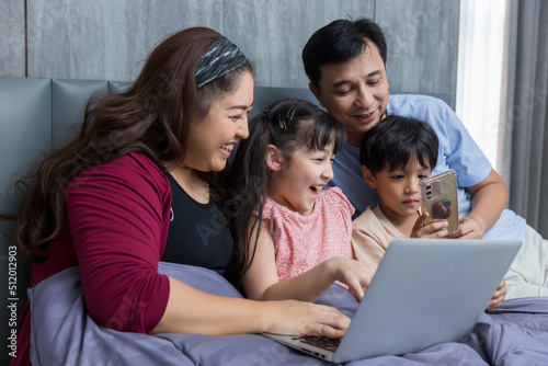 Family time together at home. Happy Family. Happy family and digital technology. family parents and son lying on the bed using smart phone.