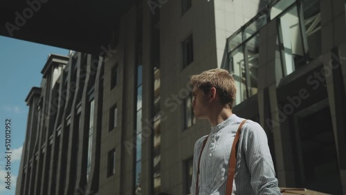 Wallpaper Mural Man looking to camera while standing outdoors business building on the background. Medium shot Portrait of male person dressed in stylish clothes . Torontodigital.ca