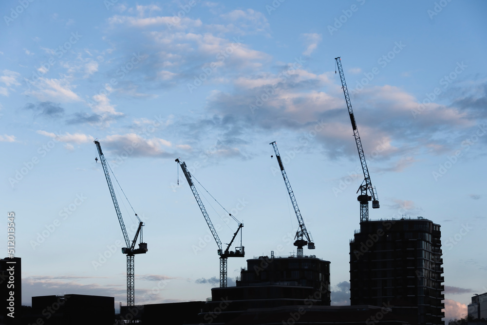 Huge industrial cranes on blue sky background