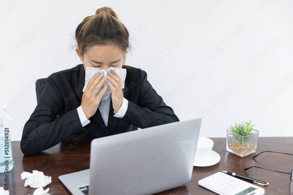 Female employee wearing a medical mask while working alone, Sickness while working. Female employee wearing a medical mask while working alone, Sickness while working.
