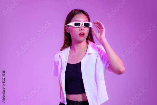 Young asian woman wearing white retro sunglasses posing on the purple screen background. © CREATIVE WONDER