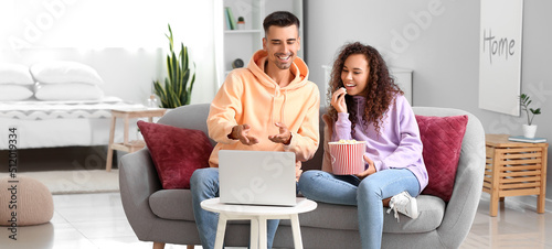 Young couple with popcorn w...