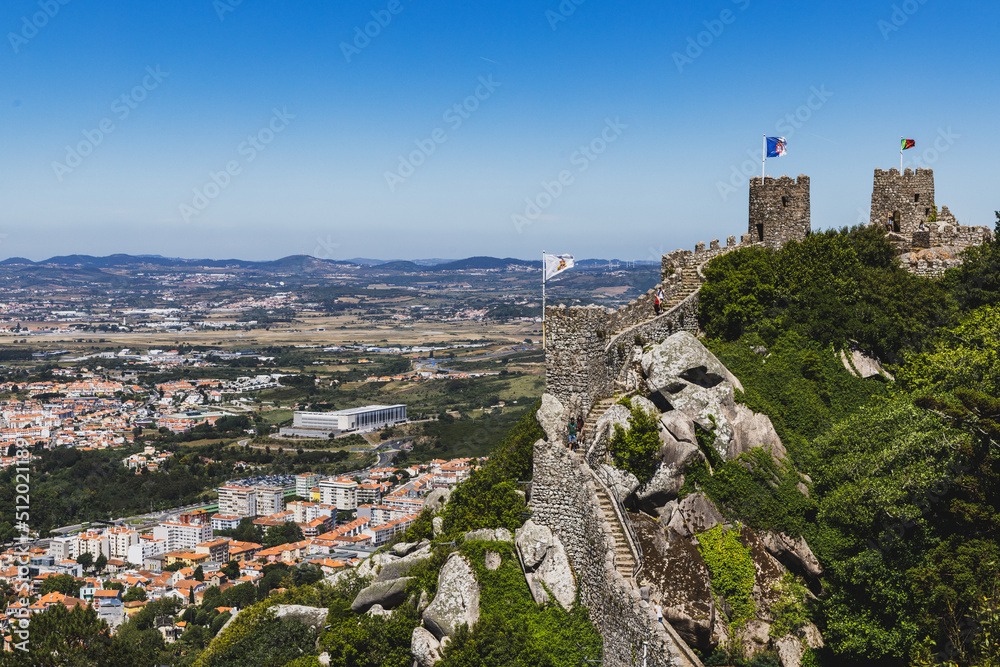 Castle ruins with a flag overlook the town of Sintra in Portugal