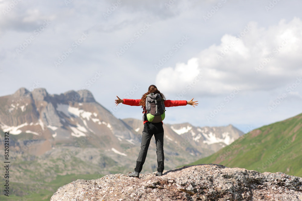 Hiker celebrating success in the top of a mountain