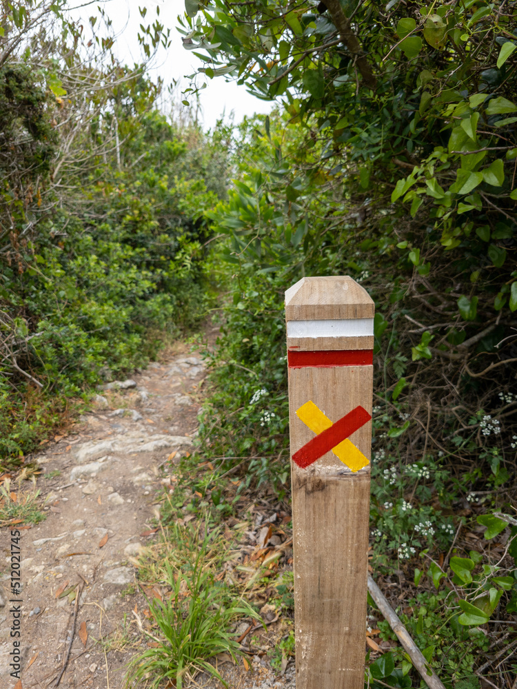 A signpost with trail markers on the side of a trail in Portugal A signpost with trail markers on the side of a trail in Portugal