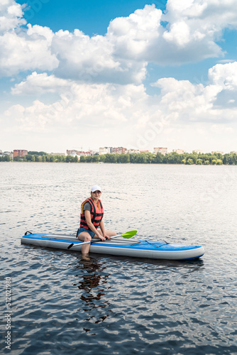 an experienced athlete in a vest rides on the water on a board sap on the lake in weather.