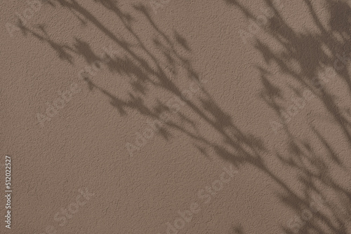 Abstract tree leaves shadows on brown concrete wall texture with roughness and irregularities. Abstract trendy colored nature concept background. Copy space for text overlay, poster mockup flat lay  photo