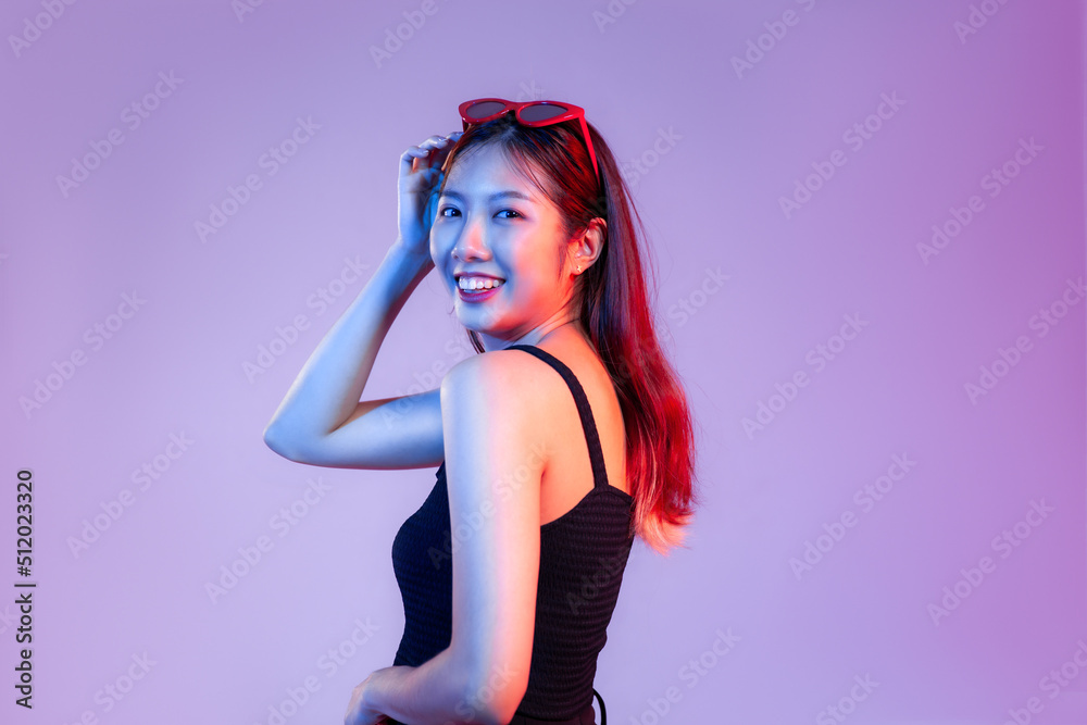 Young asian woman in black tank top posing smilling on purple background. Young asian woman in black tank top posing smilling on purple background.