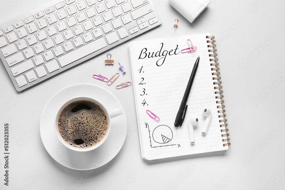 PC keyboard, notebook, cup of coffee and stationery on light background. Concept of planning budget PC keyboard, notebook, cup of coffee and stationery on light background. Concept of planning budget